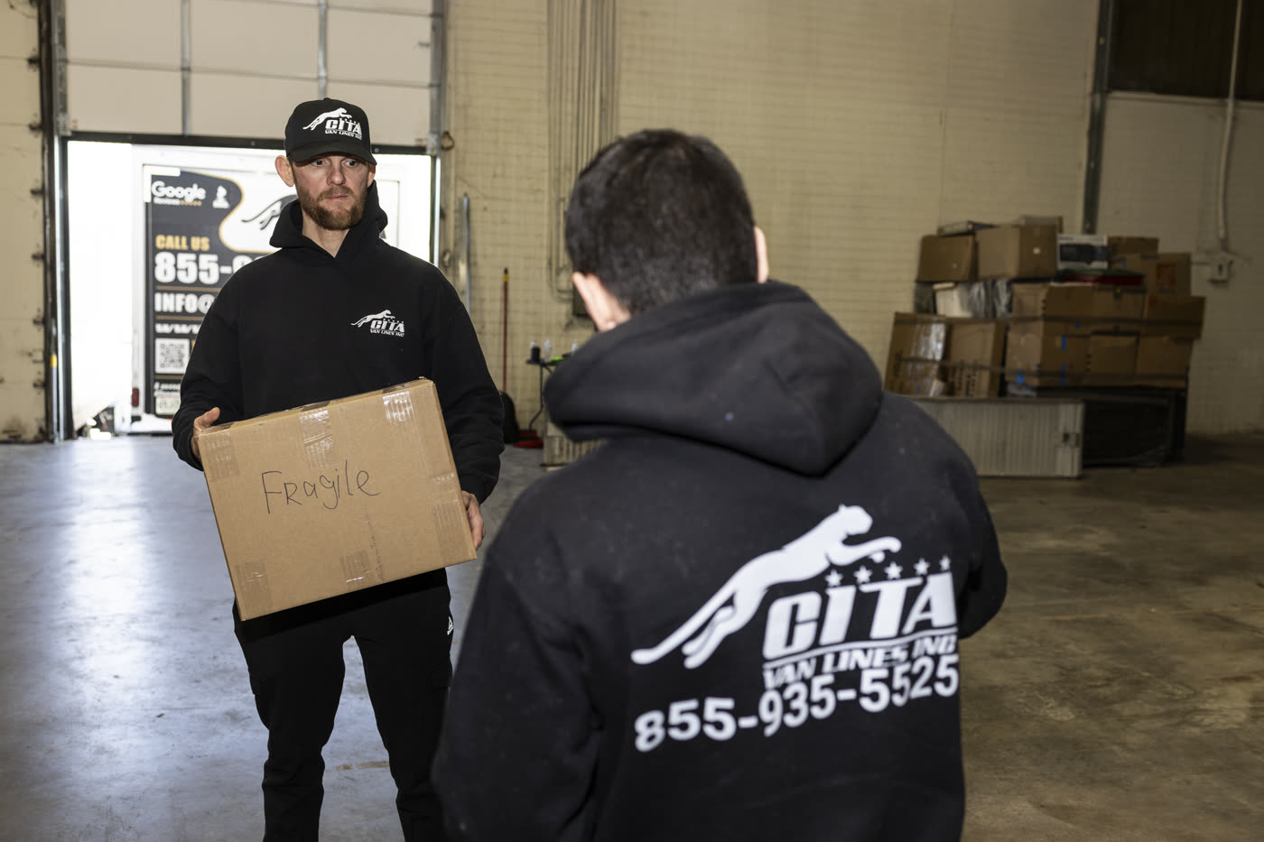 Professional movers handling a fragile box